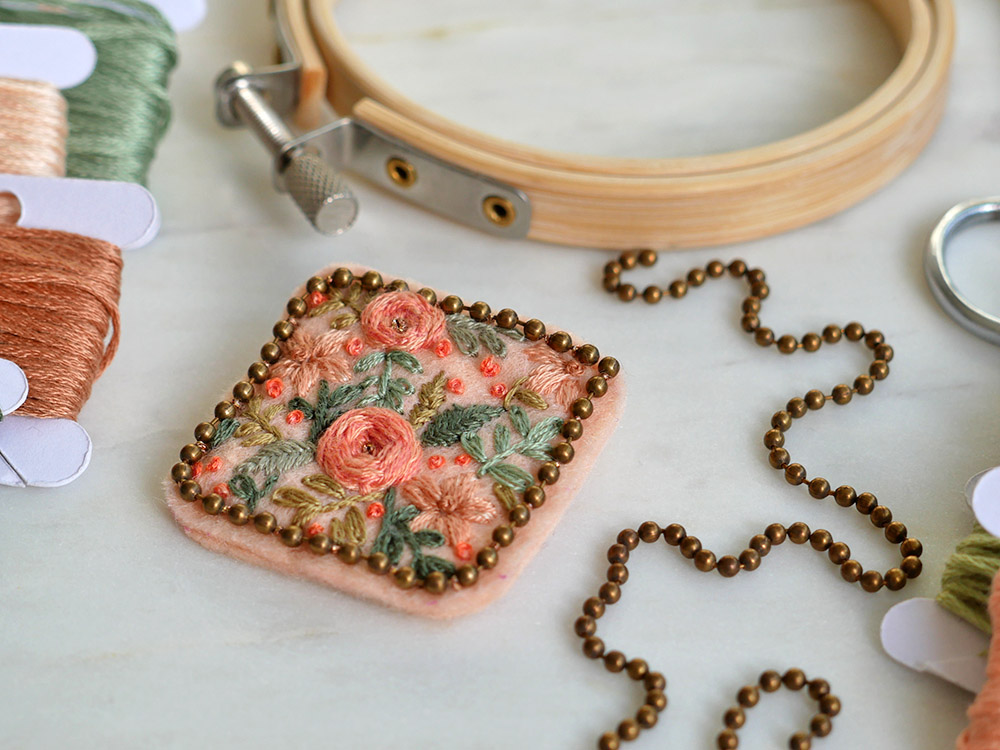 Broderie : une broche florale sur du feutre