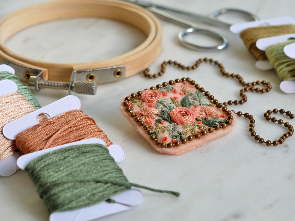 Broderie : une broche florale sur du feutre